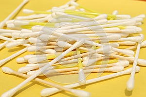 Cotton made ear buds all together close display on yellow background.