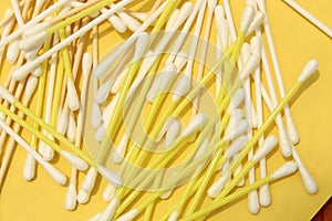 Cotton made ear buds all together close display on yellow background.