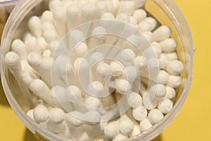 Cotton made ear buds all together close display on yellow background.