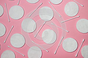 Cotton pads and cotton swabs on a pink background. Personal hygiene concept.