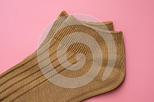 Cotton socks on a pink background top view.