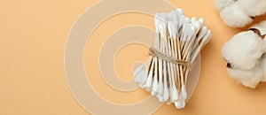 Cotton swabs and cotton on beige background