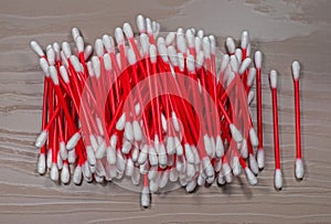 Cotton swabs folded slide. Red plastic sticks looks nice on wood background color of cappuccino.