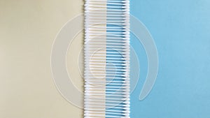 Cotton swabs on half blue and half beige background.