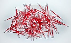 Cotton swabs stacked randomly. Red plastic sticks nicely contrasts on a light background.