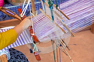 Cotton weaving. Woman hand weaving cotton on manual loom. Thai cotton handmade. Homespun fabric process. The process of fabric