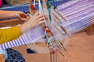 Cotton weaving. Woman hand weaving cotton on manual loom. Thai cotton handmade. Homespun fabric process. The process of fabric