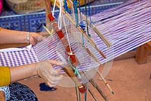 Cotton weaving. Woman hand weaving cotton on manual loom. Thai cotton handmade. Homespun fabric process. The process of fabric