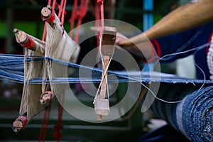 Cotton weaving. Woman hand weaving cotton in traditional way at manual loom. Traditional thailand cotton