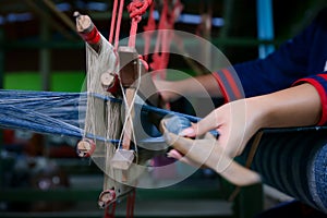 Cotton weaving. Woman hand weaving cotton in traditional way at manual loom. Traditional thailand cotton