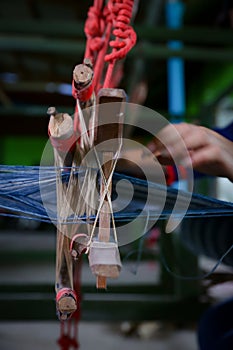 Cotton weaving. Woman hand weaving cotton in traditional way at manual loom. Traditional thailand cotton