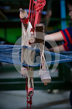 Cotton weaving. Woman hand weaving cotton in traditional way at manual loom. Traditional thailand cotton