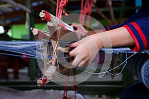 Cotton weaving. Woman hand weaving cotton in traditional way at manual loom. Traditional thailand cotton