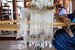 Cotton weaving. Woman weaving cotton on manual loom. Thai cotton handmade. Homespun fabric process. The process of fabric weaving