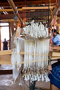 Cotton weaving. Woman weaving cotton on manual loom. Thai cotton handmade. Homespun fabric process. The process of fabric weaving