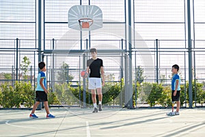 Couch playing football with two students.