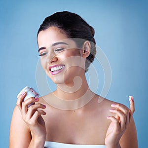 She couldnt be happier with her purchase. Studio shot of a beautiful young woman posing against a blue background.