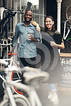 We couldnt have built this without teamwork. Full length shot of two young business owners standing outside their