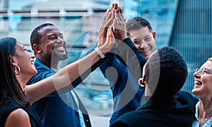 Couldnt have chosen a better group of achievers. a group of young businesspeople giving each other a high five outside.