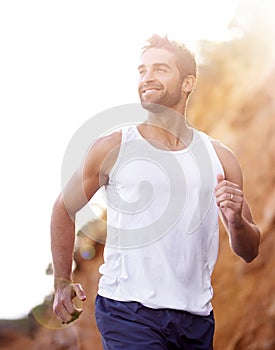 He couldnt have hoped for a nicer day to run. a handsome young man jogging outdoors.