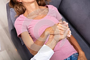 Councilor Holding Woman Hand During Hypnotherapy