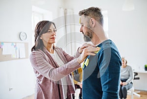 Counsellor putting an adhesive notes on client during group therapy. photo