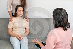 Counselor at meeting with mature woman and her teenage daughter. Psychology, family mental health, adolescence problems.