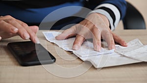 Count a family budget. Female count utility services bill on the telephone by the table.