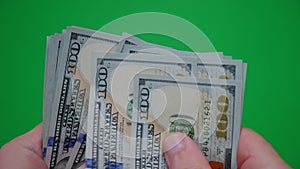 Count of money from hand to hand on a green background. Close up