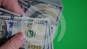 Count of money from hand to hand on a green background. Close up top view