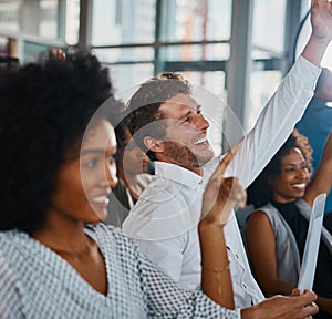 Count us in. Cropped shot of a group of young businesspeople sitting with their hands raised during a seminar in the