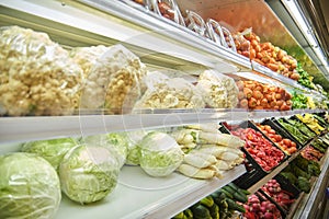 The counter with fresh fruit and vegetables in the supermarket