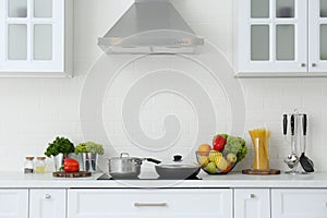 Counter with set of dishware, utensils and products in stylish kitchen