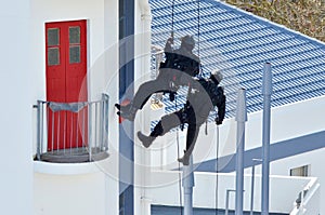 Counter-terrorism police officers abseiling a building