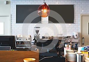 Counter top at a bright cafe with empty blackboards on the wall for copy space