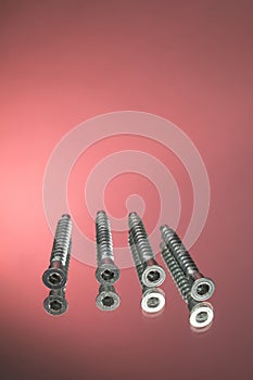 Countersunk wood screws on a red background