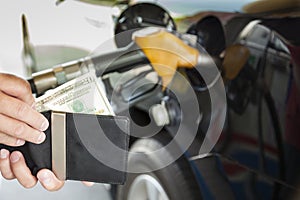 counting money with gasoline refueling car photo