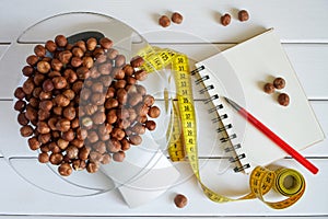 Counting and recording the amount of protein, calories, carbohydrates and fats in food. Hazelnut on kitchen scales