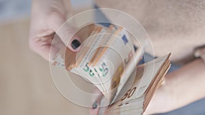 Counting Wealth: Woman's Hands with Black Nails Tallying 50 Euro Banknotes