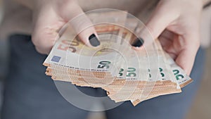 Counting Wealth: Woman's Hands with Black Nails Tallying 50 Euro Banknotes