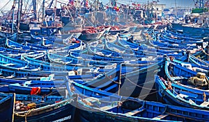 Countless old blue wooden traditional fishing boats crammed together in overcrowded no space full north african harbor  -