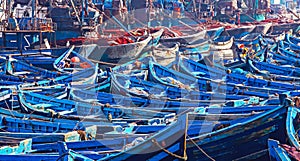 Countless old blue wooden traditional fishing boats crammed together in overcrowded no space full north african harbor  -