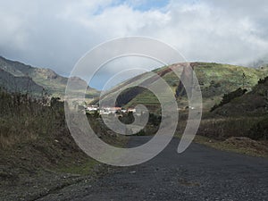 Country asphalt road to small village Las Portelas. Landscape with strange divided hill with terraced fields at Park