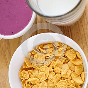 A country breakfast with blueberry yogurt, milk and cornflakes