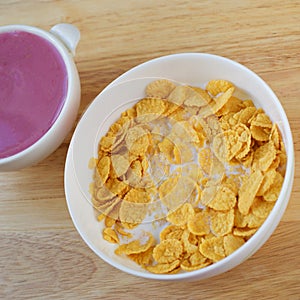 A country breakfast with blueberry yogurt, milk and cornflakes