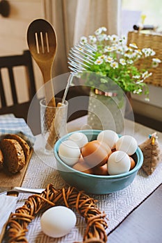 Country breakfast on rustic home kitchen with farm eggs, butter, wholegrain bread and milk.