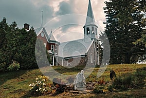 country church near the presbytery with big threatening clouds in the sky, ste-elie