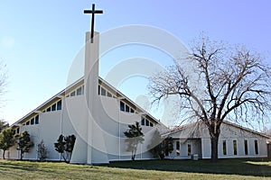Country church with peaked roof, cross and blue sky