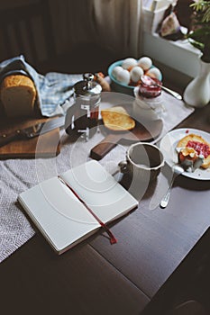 Country cottage kitchen with breakfast on wooden table.