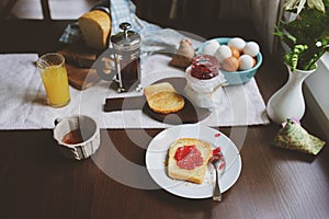 Country cottage kitchen with breakfast on wooden table.